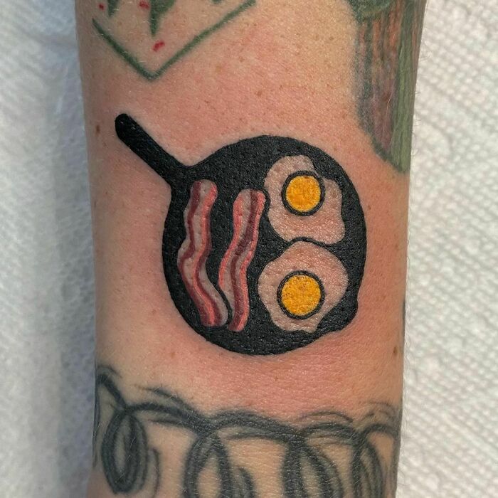 Pan of fried eggs and bacon watercolor tattoo