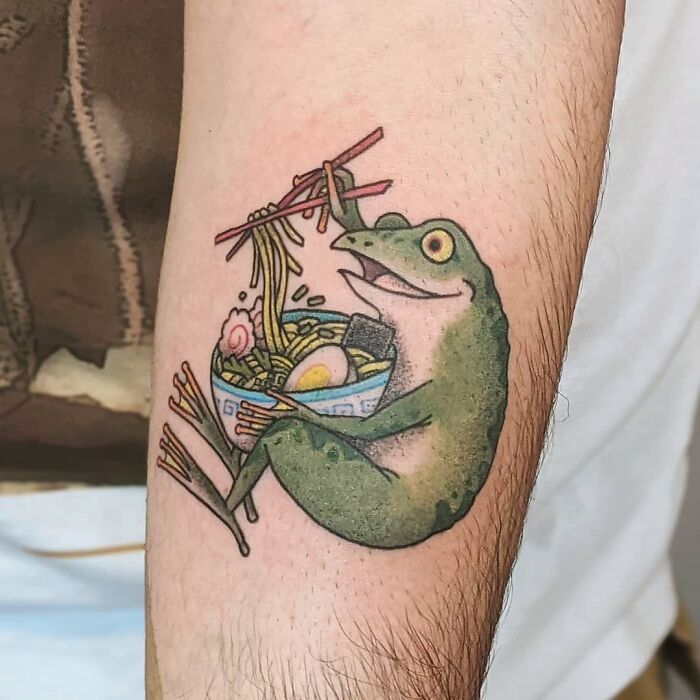 Watercolor tattoo of a frog enjoying Chinese food, showcasing creative food tattoo ideas on arm.