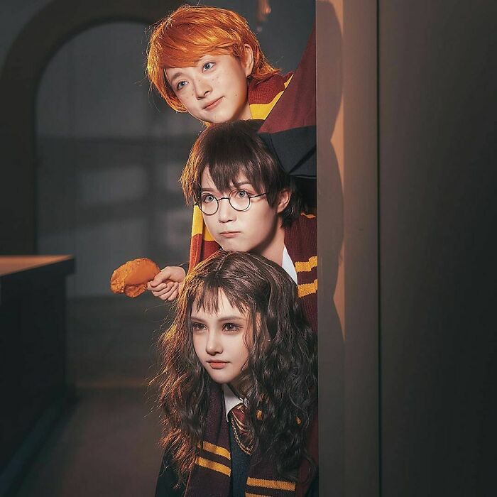 Person cosplaying young Ron, Harry and Hermione from Harry Potter