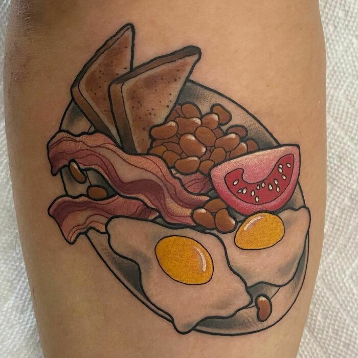 Watercolor food tattoo featuring eggs, bacon, beans, toast, and tomato.