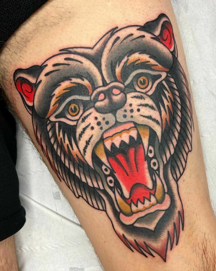 Roaring bear American traditional tattoo design on thigh, showcasing bold lines and vivid colors.