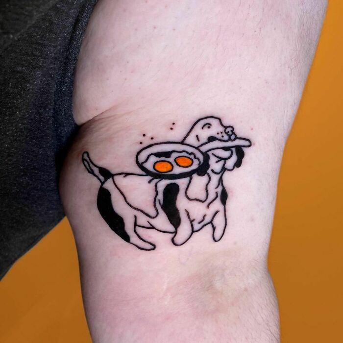 Watercolor tattoo of a dog holding a pan with eggs, showcasing creative food ink-spiration.