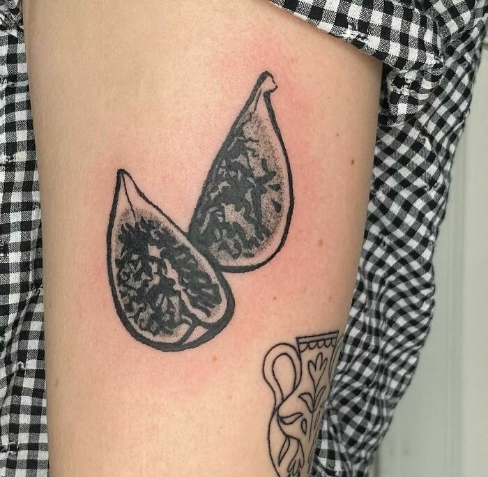 Black and white tattoo of figs on an arm, showcasing food-inspired ink art.