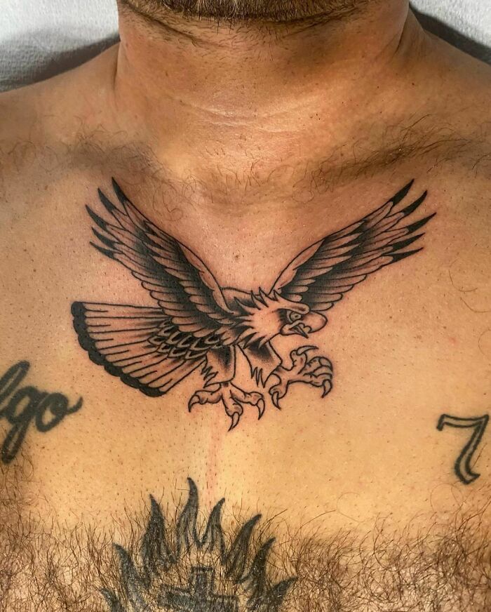 American traditional tattoo of an eagle on a man's chest, showcasing bold and striking design elements.