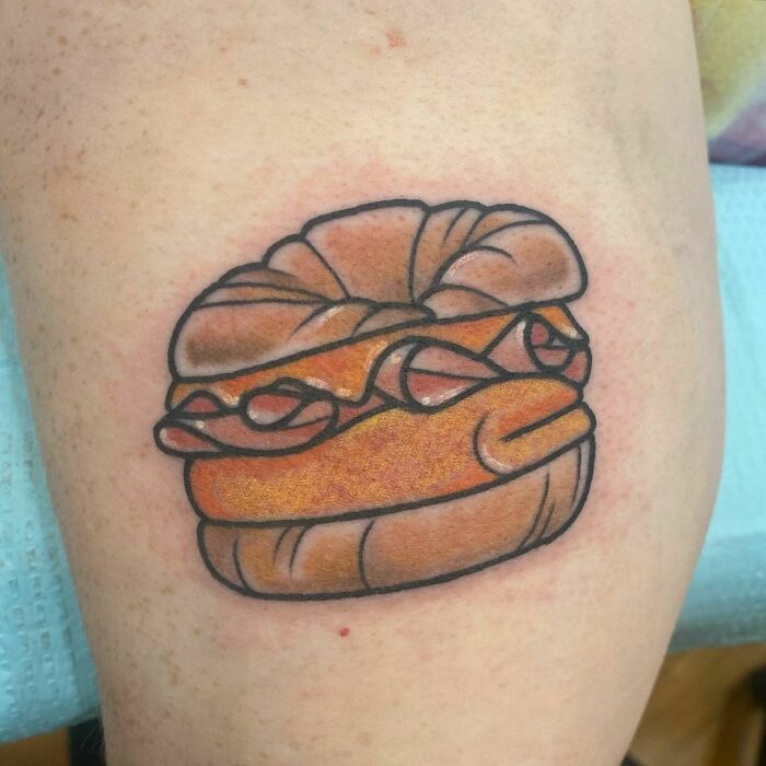 Watercolor tattoo of a bagel on skin, highlighting colorful food ink-spiration.