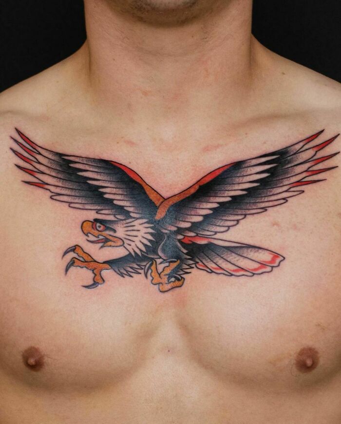 American traditional tattoo of an eagle on a man's chest, featuring bold outlines and classic color palette.