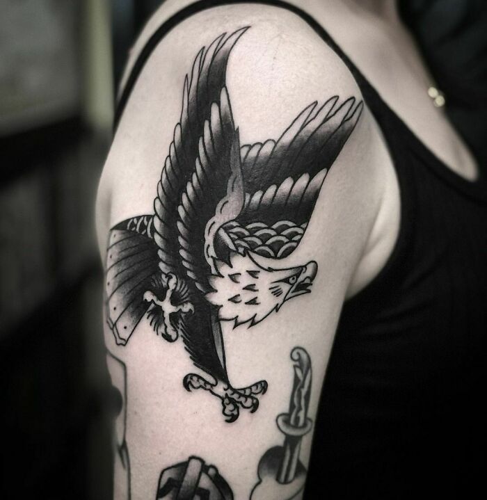 American traditional tattoo of an eagle on a person's upper arm, showcasing bold lines and classic design.