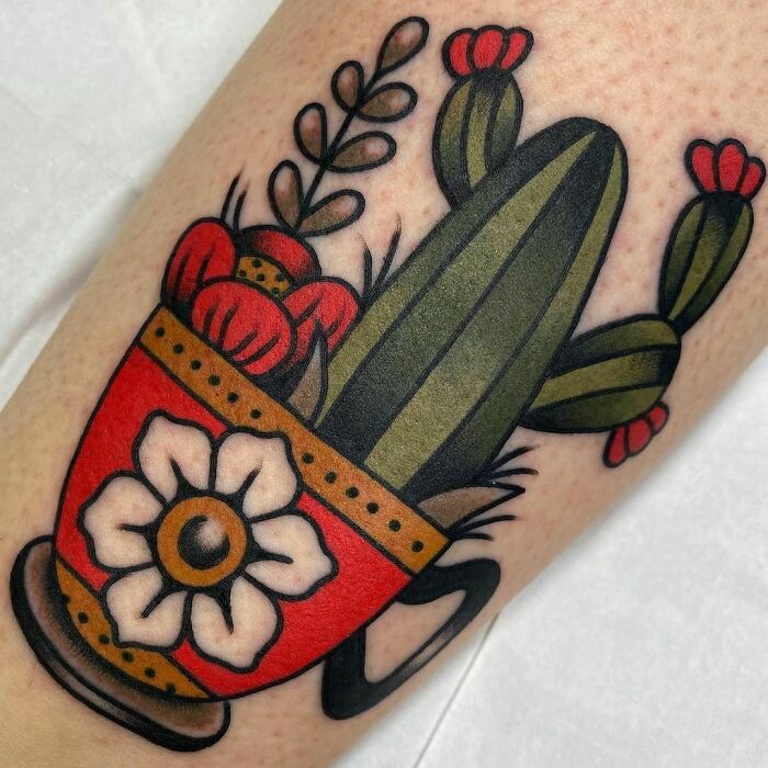 American traditional tattoo of a cactus in a red pot with a flower, showcasing bold colors and classic design elements.