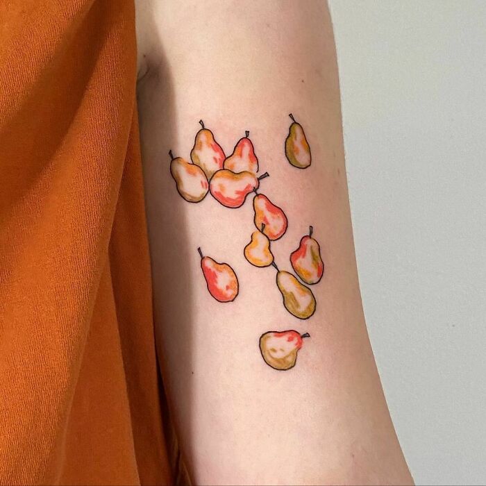 Watercolor tattoo of falling pears on arm, featuring vibrant ink-spiration food art.