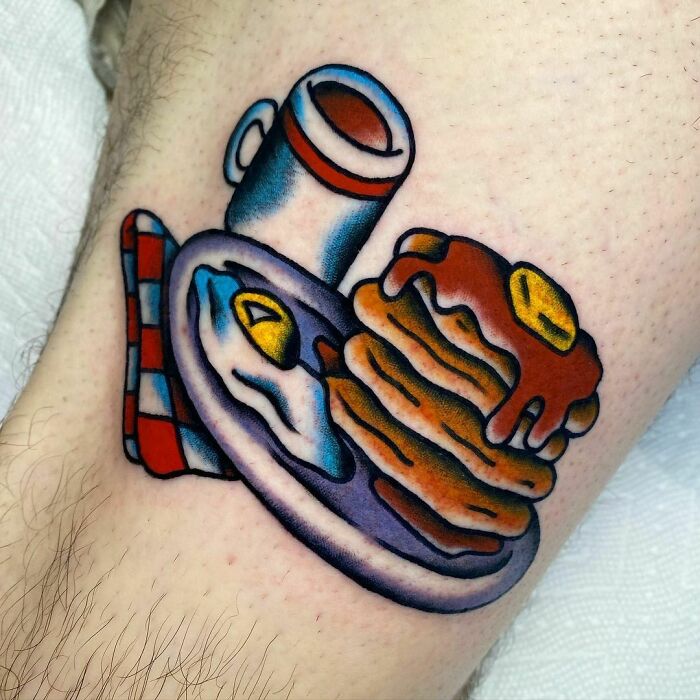 Watercolor tattoo of pancakes and eggs on a plate, showcasing a creative food tattoo design.