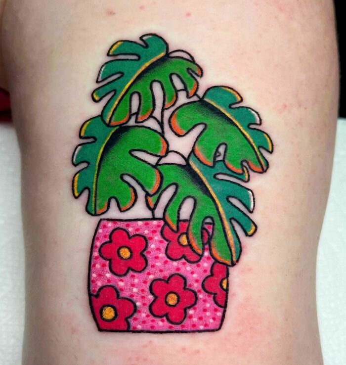 American traditional tattoo of green leaves in a pink floral pot.