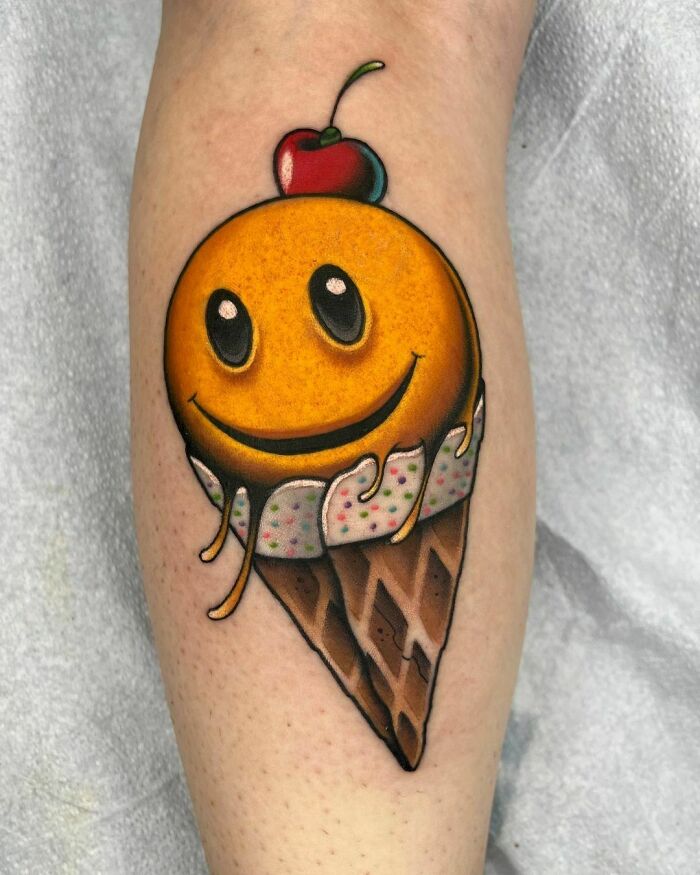 Smiley ice cream cone watercolor tattoo featuring colorful details and a cherry on top. Food tattoo inspiration.