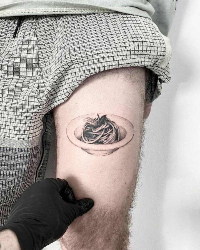 Minimalistic pasta tattoo on thigh showcasing creative food ink-spiration.