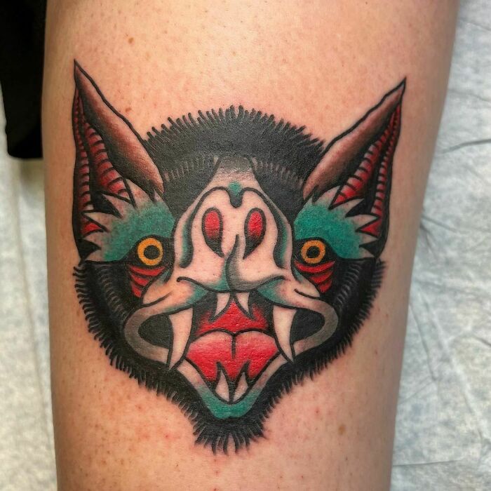 American traditional tattoo of a colorful bat with vivid details on forearm.