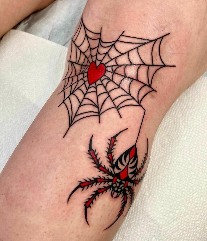 American traditional tattoo with a spider and web, featuring a red heart on the web.