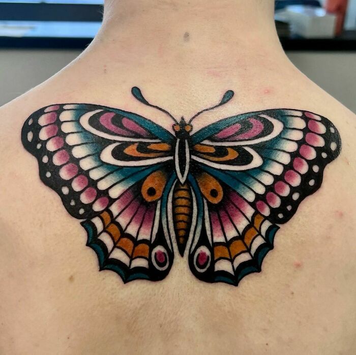 Butterfly American traditional tattoo with vibrant colors on upper back.