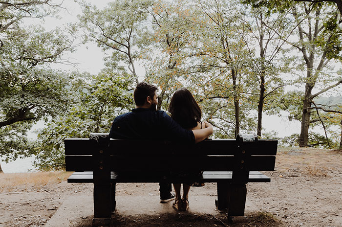 Couple sitting on black wooden bench