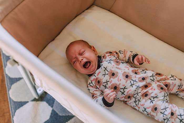 Baby crying while lying down on crib