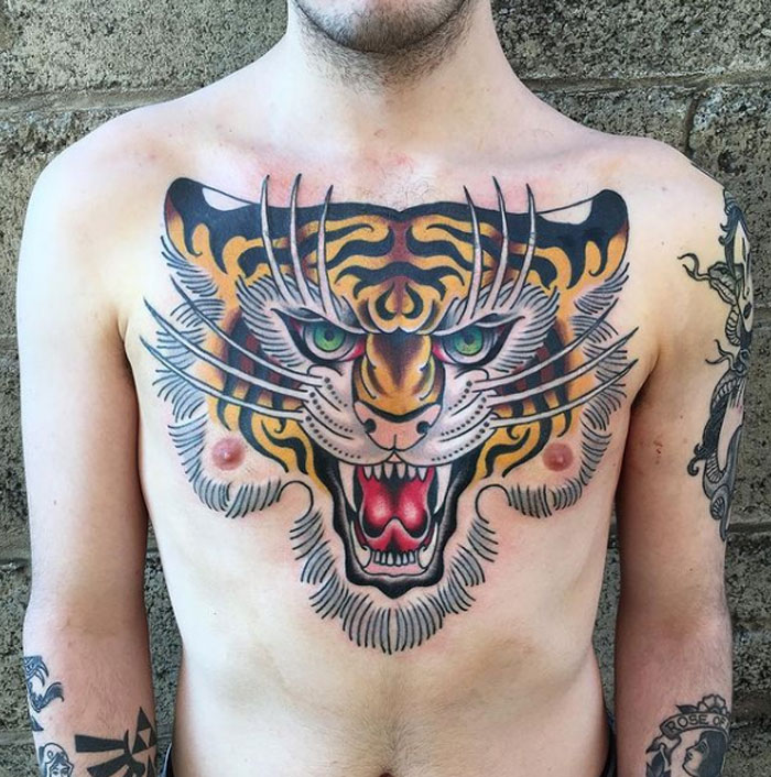 Chest tattoo of a fierce tiger in vibrant colors, showcasing American traditional tattoo style.