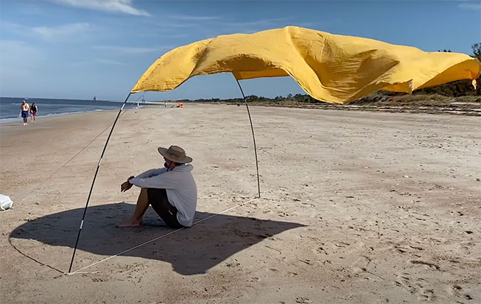 Man sitting under sunshade at the beach