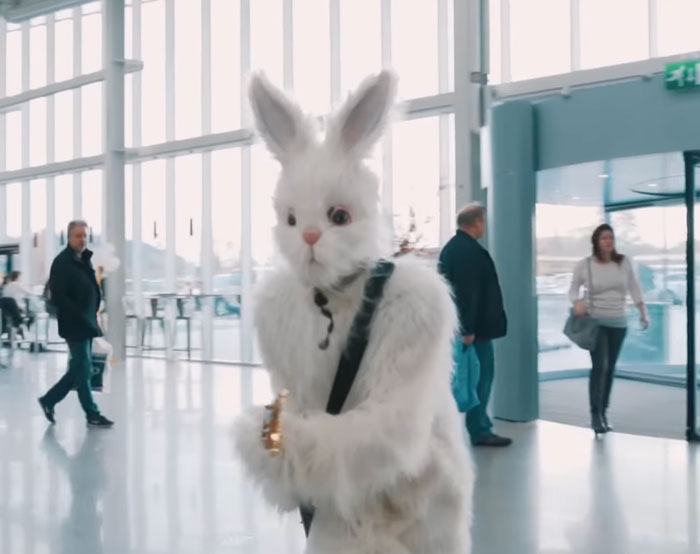 Person dressed in a rabbit suit walking in an airport 