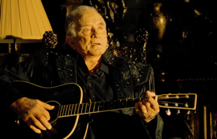 Johnny Cash Sitting and playing a guitar 