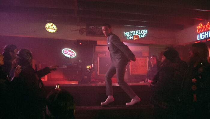 Pee-wee Herman dancing on a table in the bar