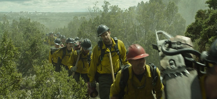 A group of firefighters walking somewhere in the forest