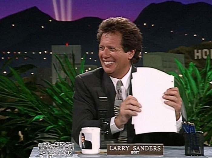 Nes reposter smiling with paper in his hands 