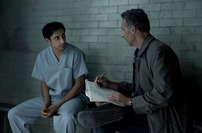 Man taking notes of what other man is saying 