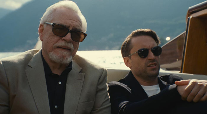 Old man and other man with sunglasses sitting in a boat 