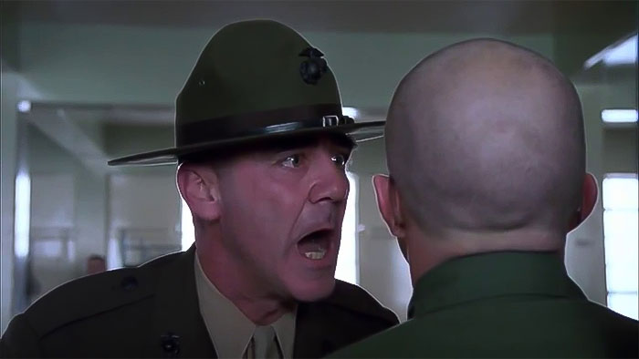 Sergeant J. T. "Joker" Davis wearing a hat and yelling 
