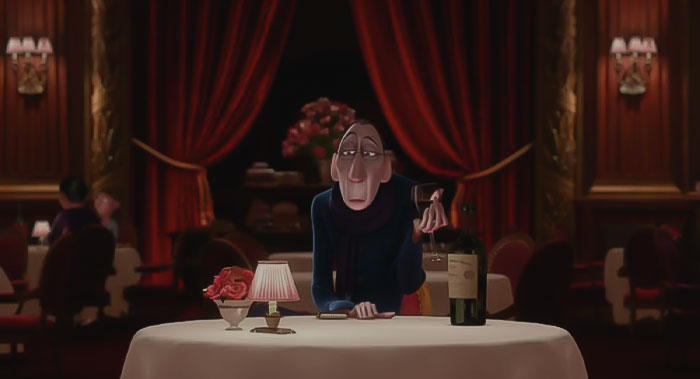 Anton Ego sitting at the table 