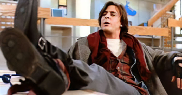 John Bender from The Breakfast Club movie talking while putting his feet up on the table