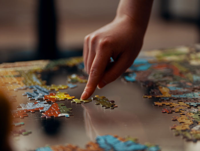 Person adding puzzle pieces in the right spot 