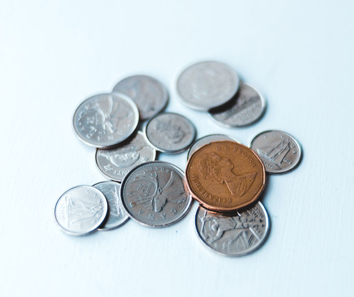 One bronze coin near a multiple silver coins 