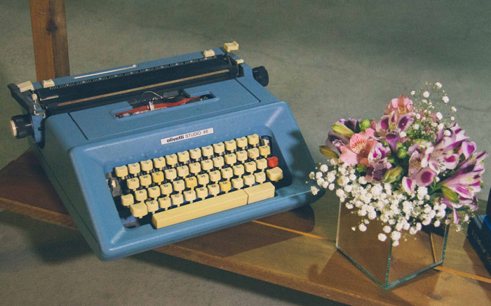 Blue typewriter and a bouquet of flowers 