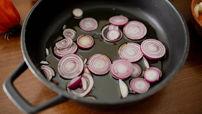 Red onions in black round plate