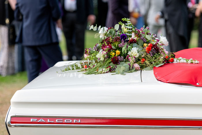 coffin with flower on top of it 