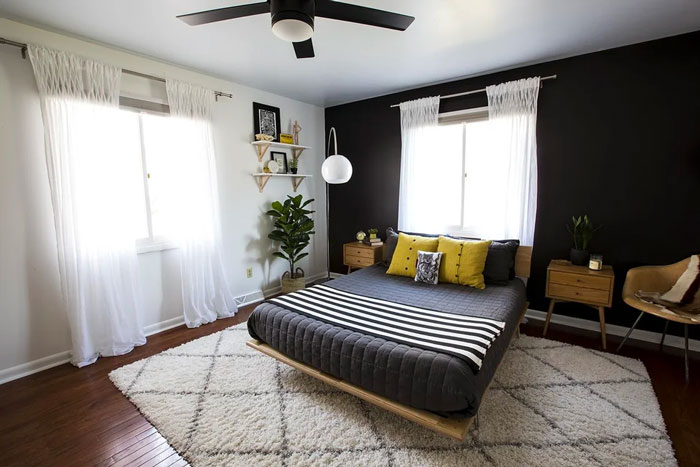 Modern bedroom decoration with a black accent wall, stylish furniture, and creative decor elements for inspiration.