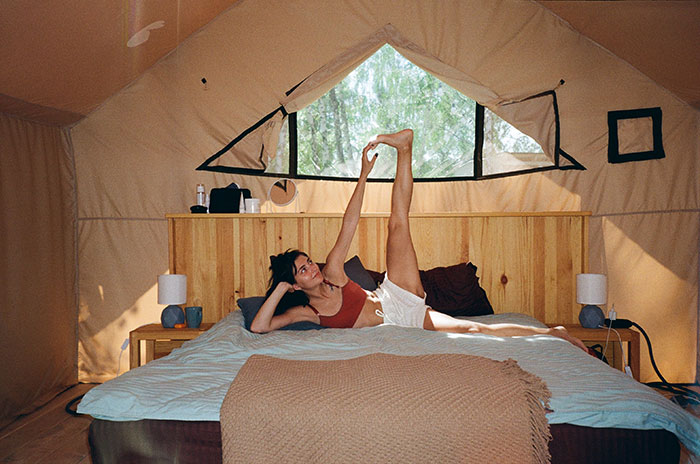 Girl doing yoga in the camp tent