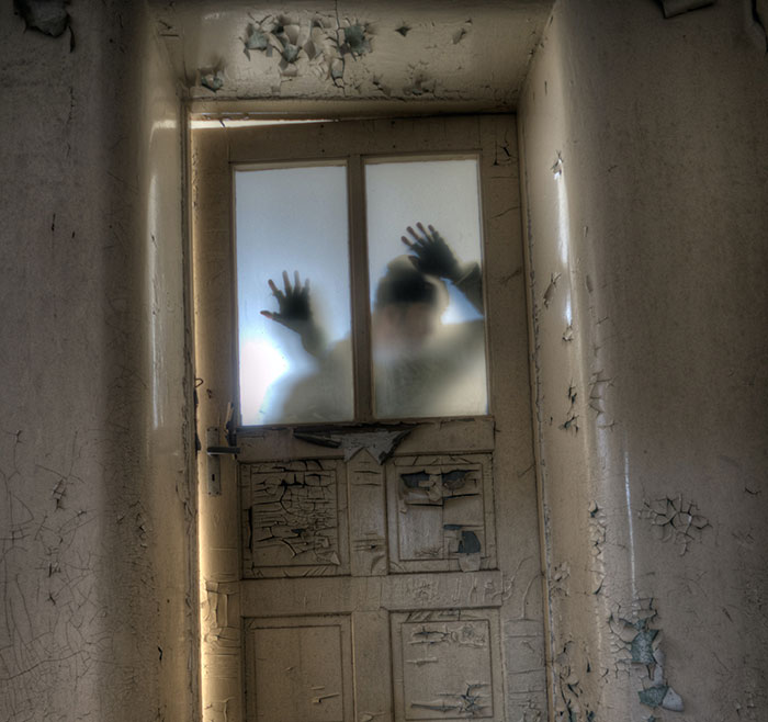 Person looking through door window