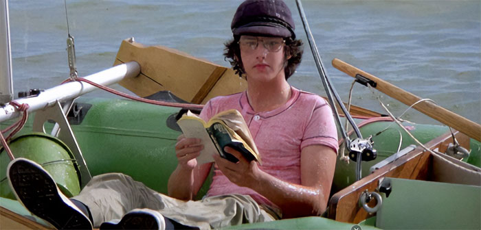 Keith Gordon reading a book while in a boat 