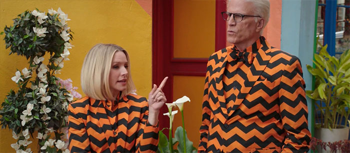 Eleanor and Michael wearing orange suits with black stripes 