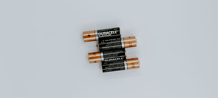 Four black Duracell batteries on white background