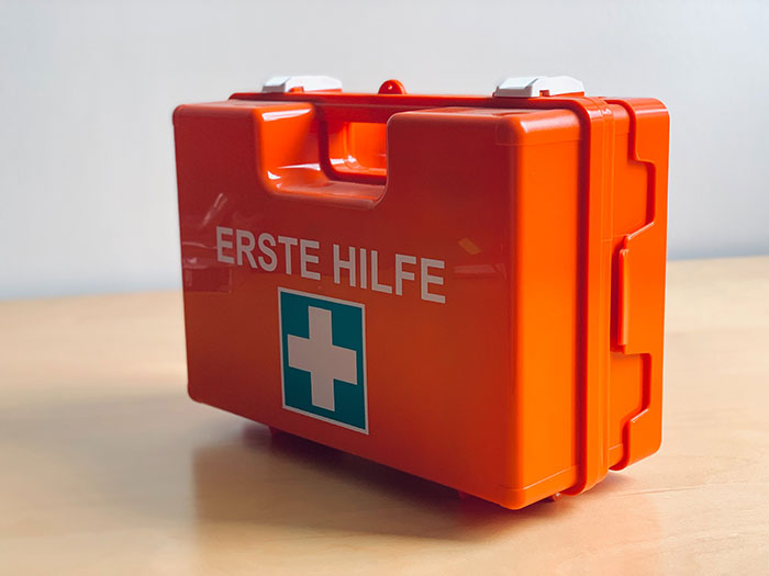 Orange Erste Hilfe med kit on wooden table