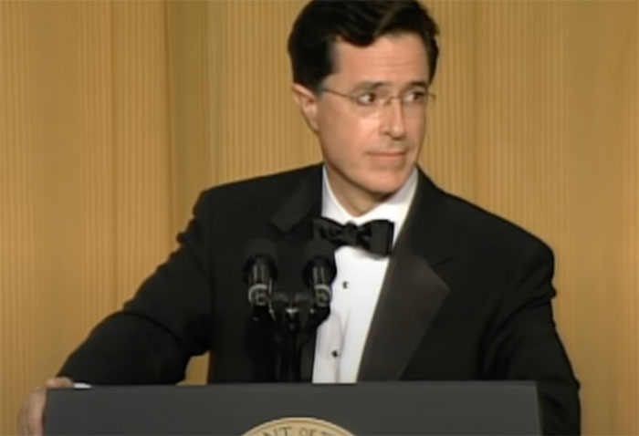 Man in a tuxedo delivers a roast at a podium, showcasing the timeless art of witty remarks.