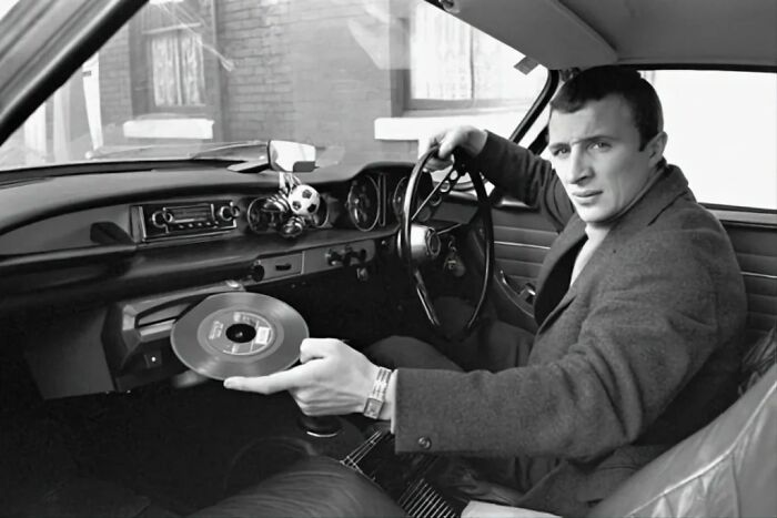 Manchester City Player Mike Summerbee Demonstrating The Built- In Record Player Of His New Volvo P1800 (1967)