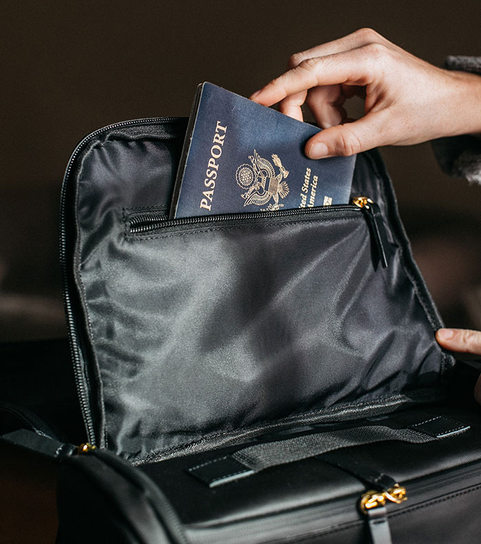 Person putting his passport in the backpack 