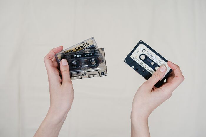 Person Holding Compact Cassette Tape In Hands 